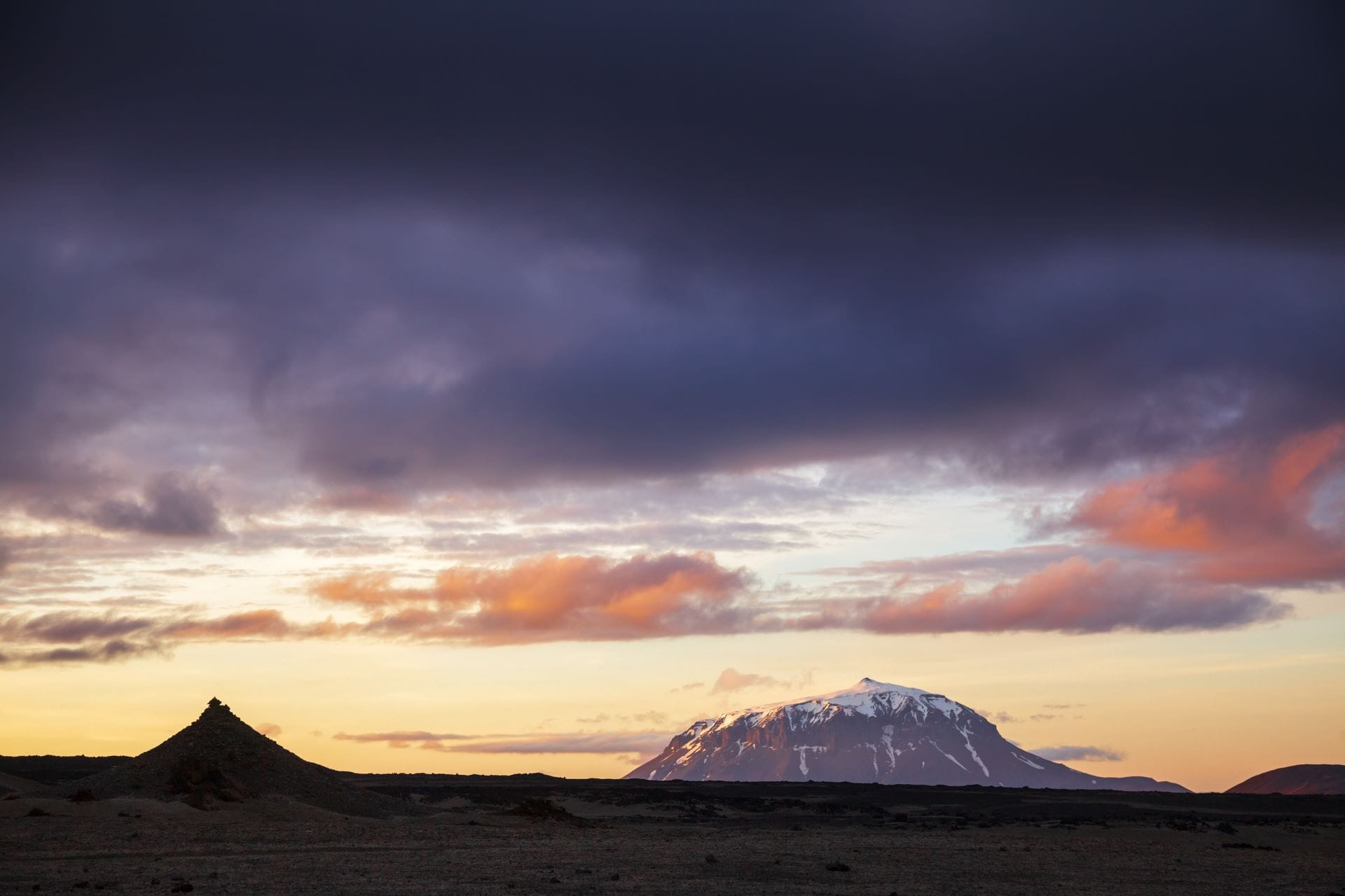 Tramonto drammatico con luce arancione sulla montagna a tavola Herðubreið che si erge solitaria sopra il campo lavico scuro dell'Ódáðahraun negli altopiani d'Islanda.