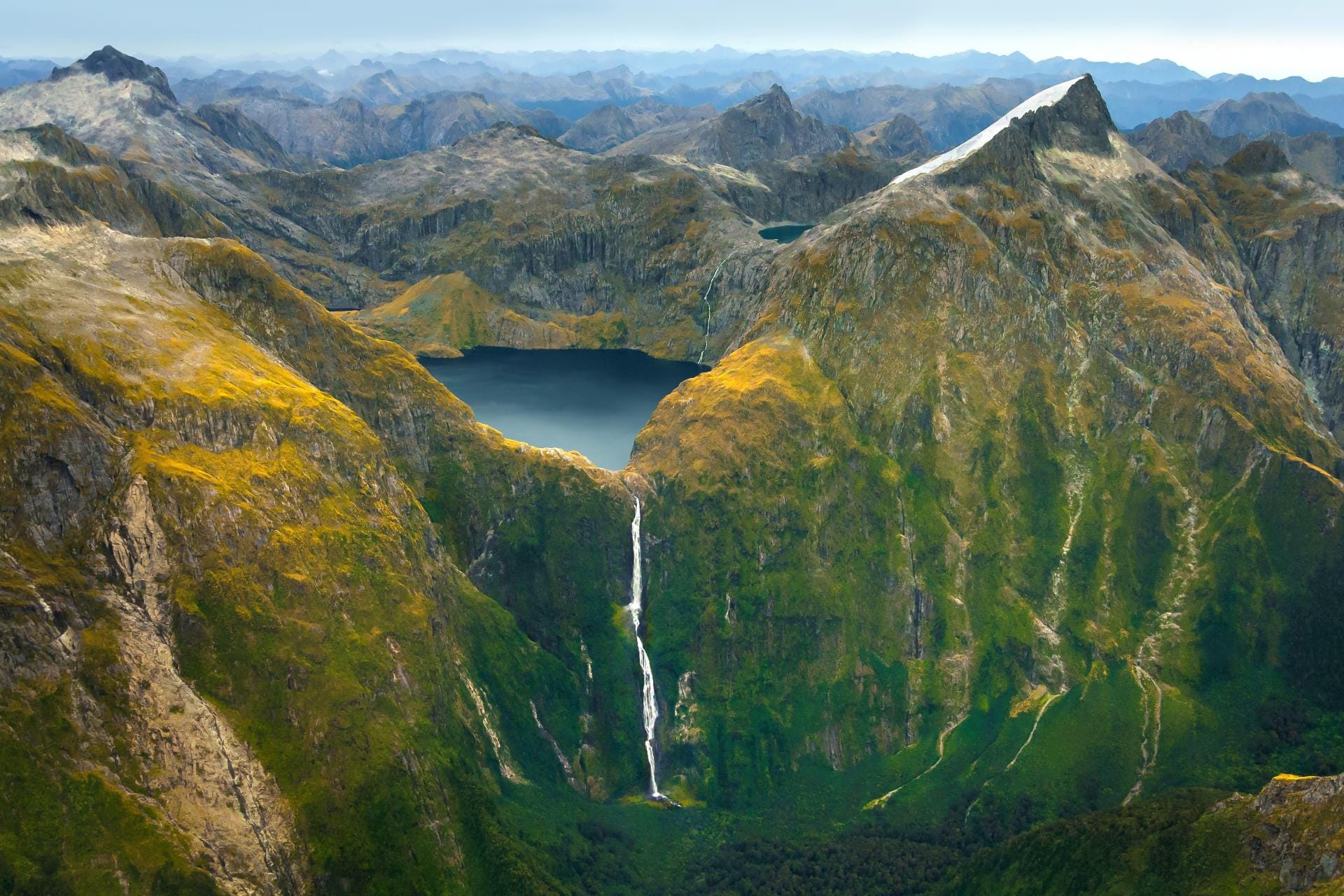 Vista aerea spettacolare catturata durante il volo panoramico da Milford Sound a Queenstown che mostra il lago alpino Lake Quill e le imponenti Sutherland Falls nel Fiordland