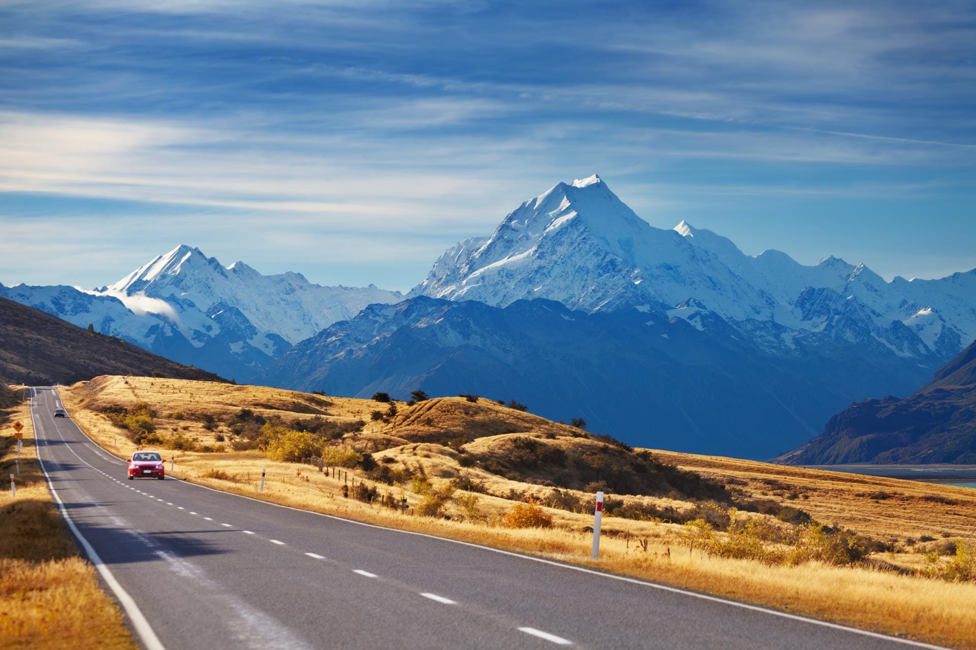 La famosa strada panoramica che conduce verso l'Aoraki Mount Cook National Park nell'Isola del Sud della Nuova Zelanda, con la montagna innevata che domina l'orizzonte.