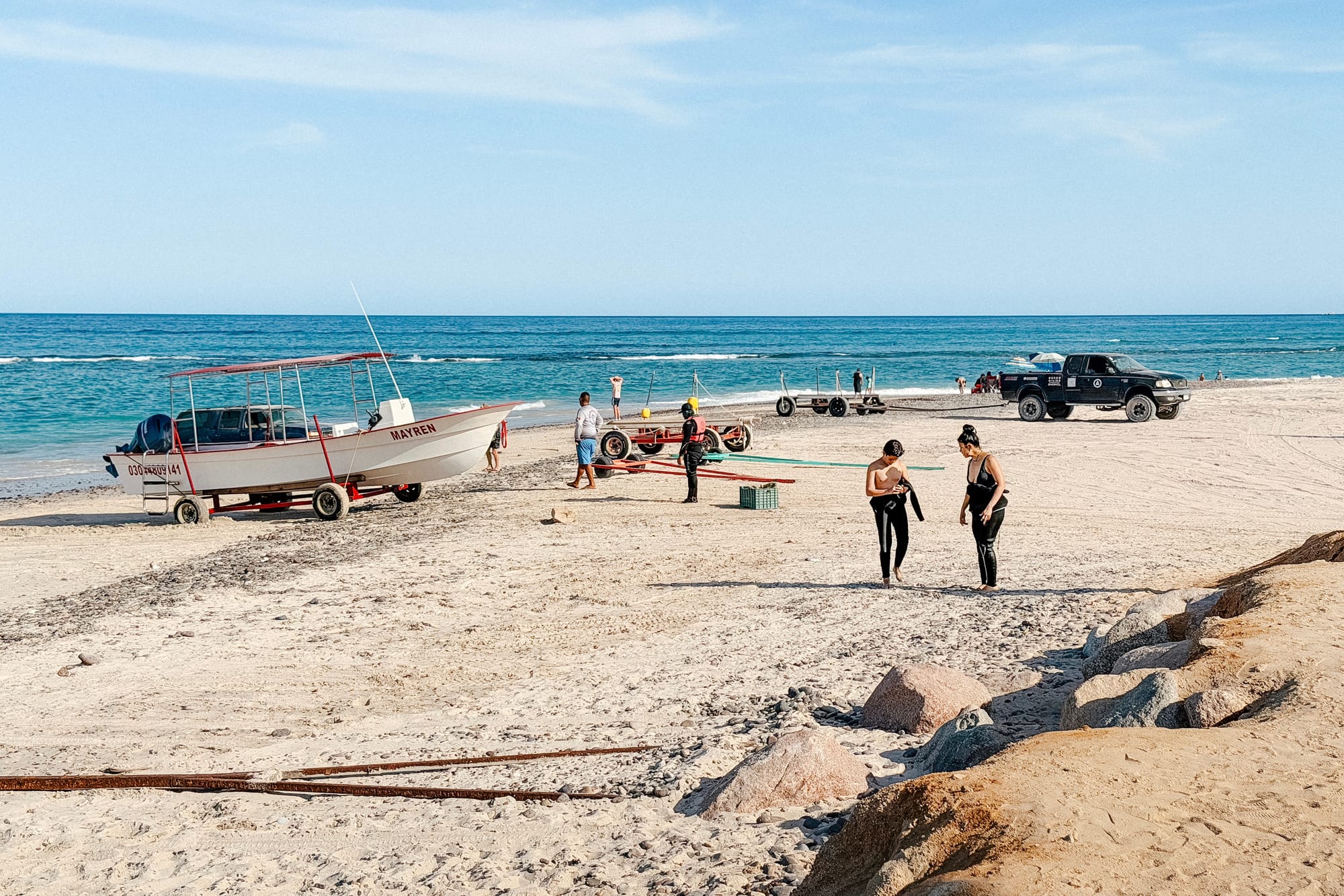 Bagnanti e visitatori camminano sulla spiaggia incontaminata di Cabo Pulmo al termine della giornata.